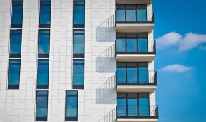 Fachada moderna de un edificio de vivienda VPO con balcones y grandes ventanales.